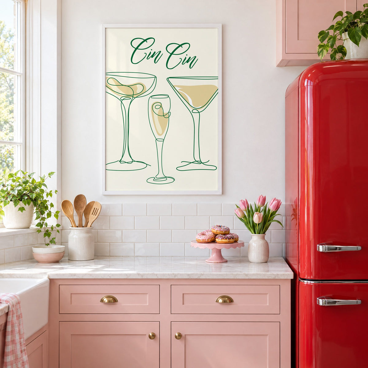 Cin Cin one-line coupe, flute and martini print in a white frame above pink cabinets beside a red retro fridge