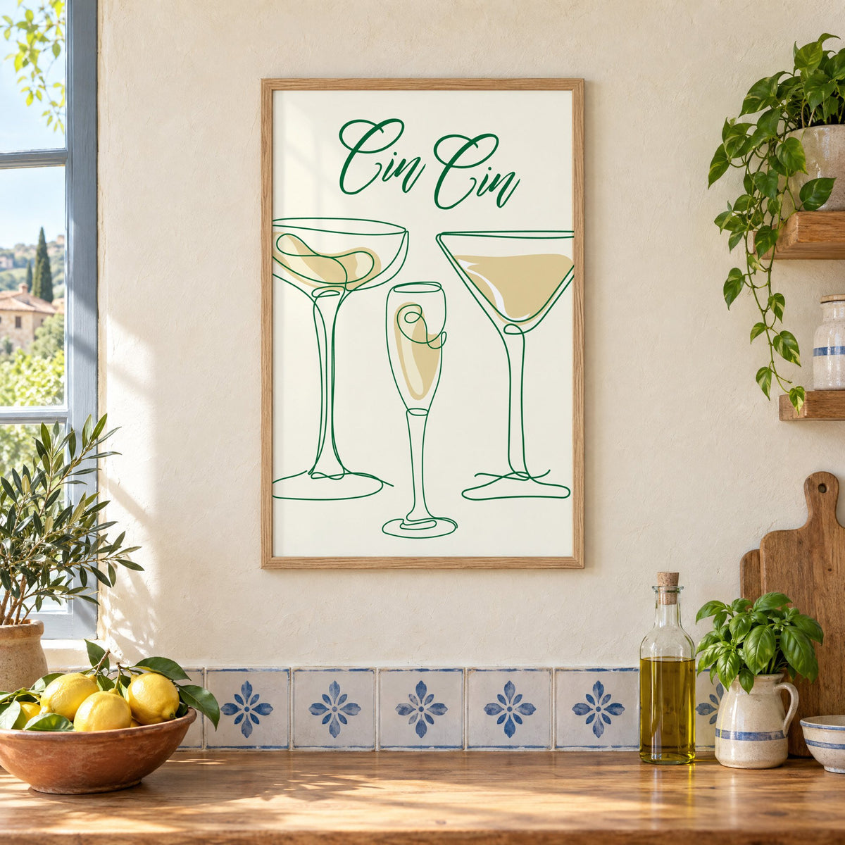 Cin Cin one-line coupe, flute and martini print in an oak frame on a cream plaster wall above a worktop with a bowl of lemons and blue-and-white tiles