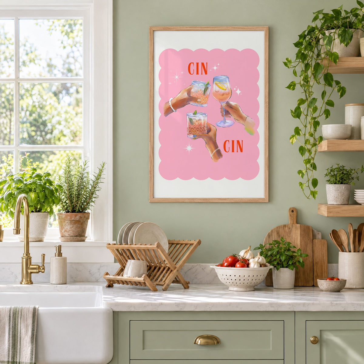 Cin Cin three hands toasting print in an oak frame on a sage green kitchen wall beside a farmhouse sink and herbs