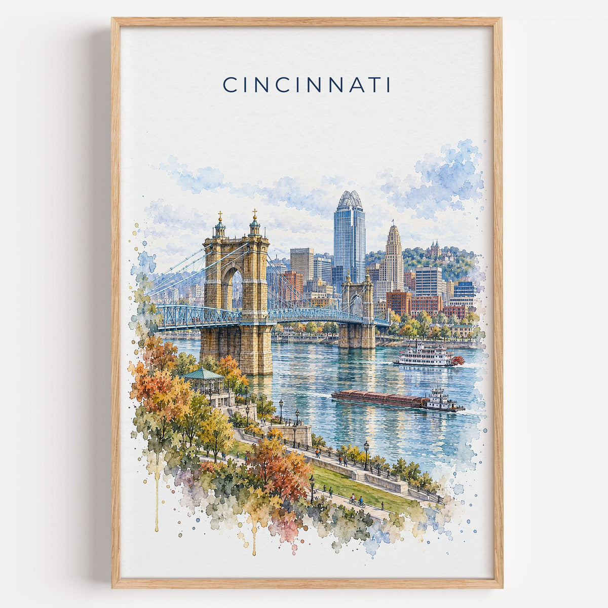 Cincinnati watercolor print in a light oak frame on a plain white wall