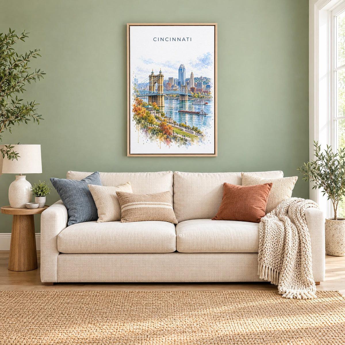 Cincinnati watercolor print as a natural floater canvas above a cream linen sofa on a sage green wall