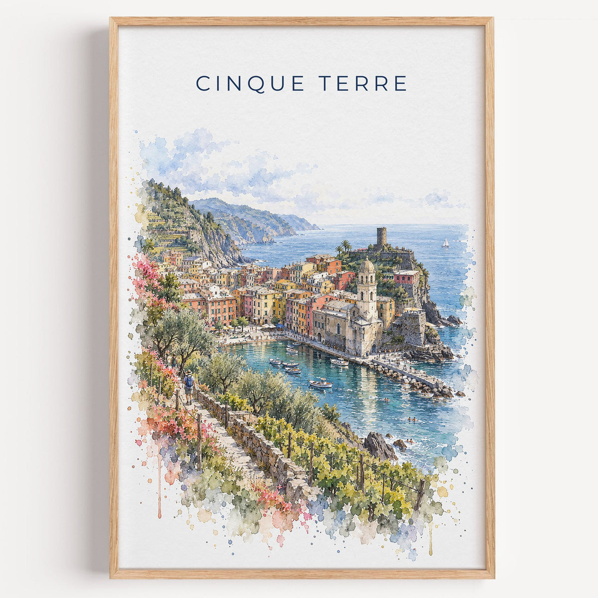 Cinque Terre watercolor print in a light oak frame on a plain white wall
