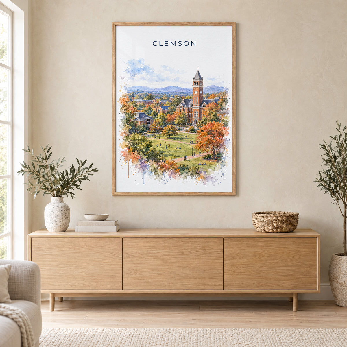 Clemson watercolor print in an oak frame above a light wood sideboard in a Scandinavian living room