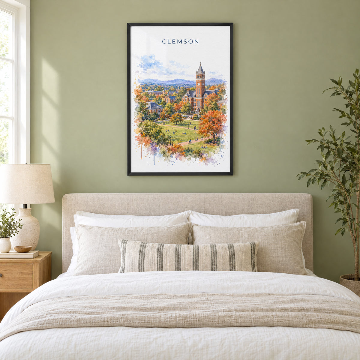 Clemson watercolor print in a black frame above an upholstered headboard in a sage green bedroom