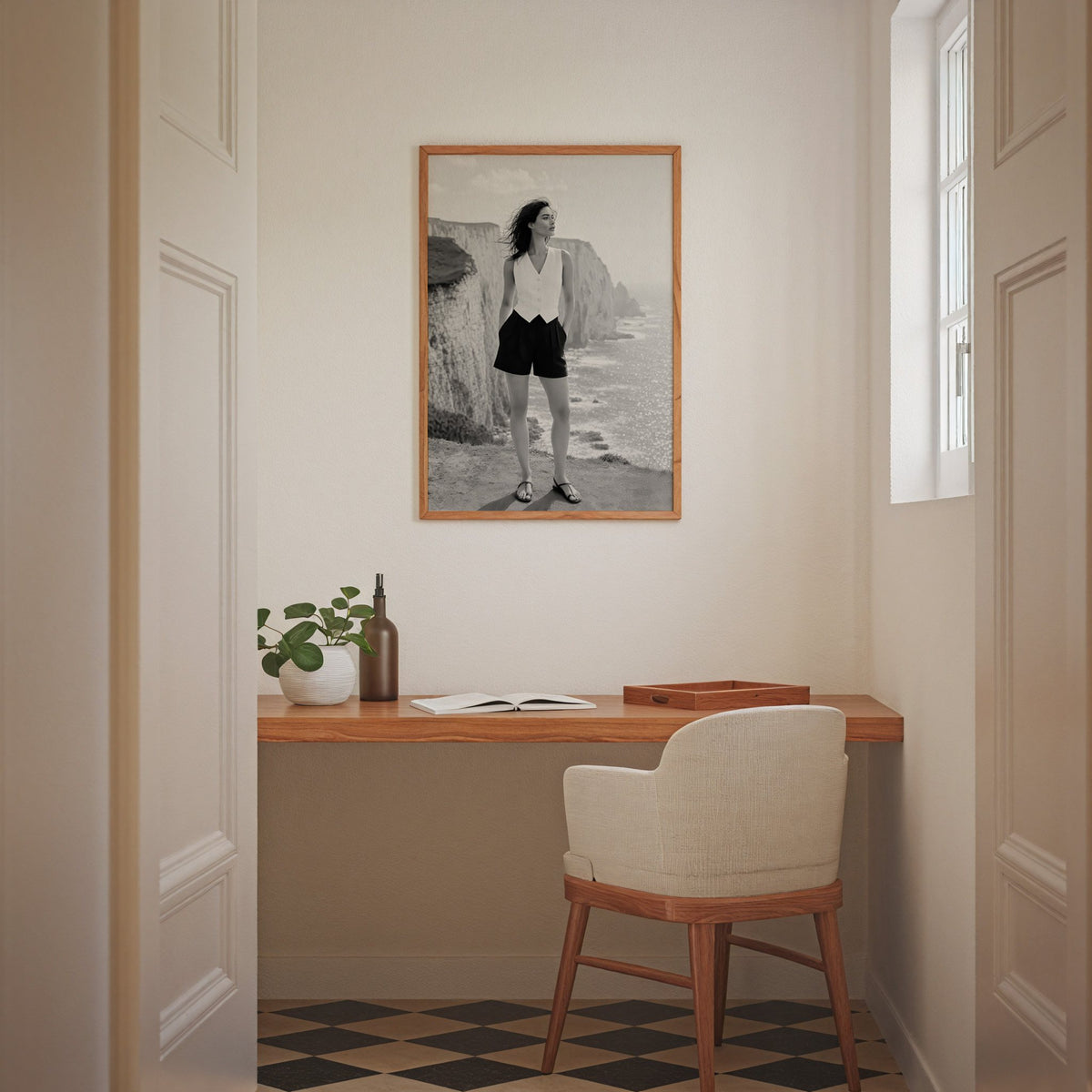 Black and white model in white vest on cliffs print in an oak frame above a home office desk nook