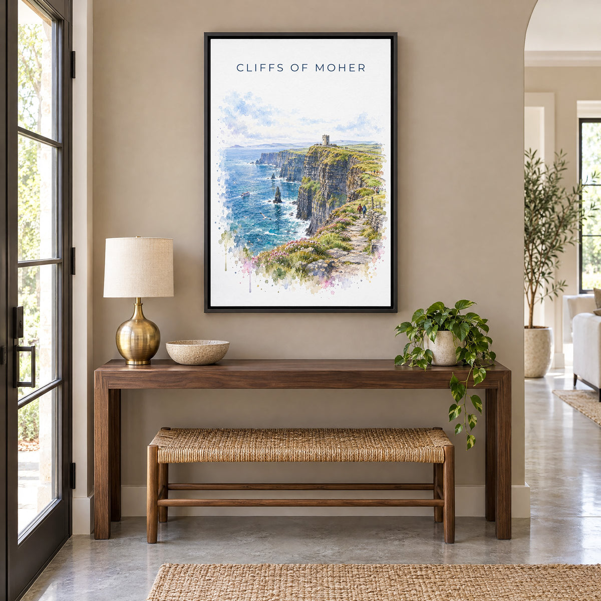Cliffs of Moher watercolor print as a black floater canvas above a walnut console and woven bench in an entryway