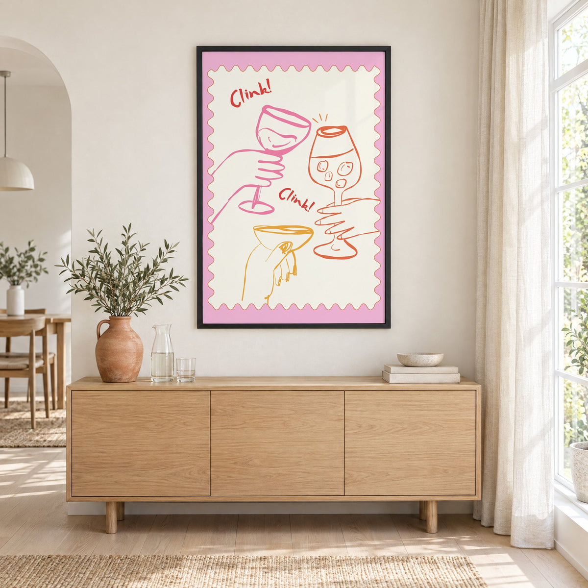 Clink Clink three glasses toast print in a black frame above an oak sideboard with a terracotta vase of olive branches