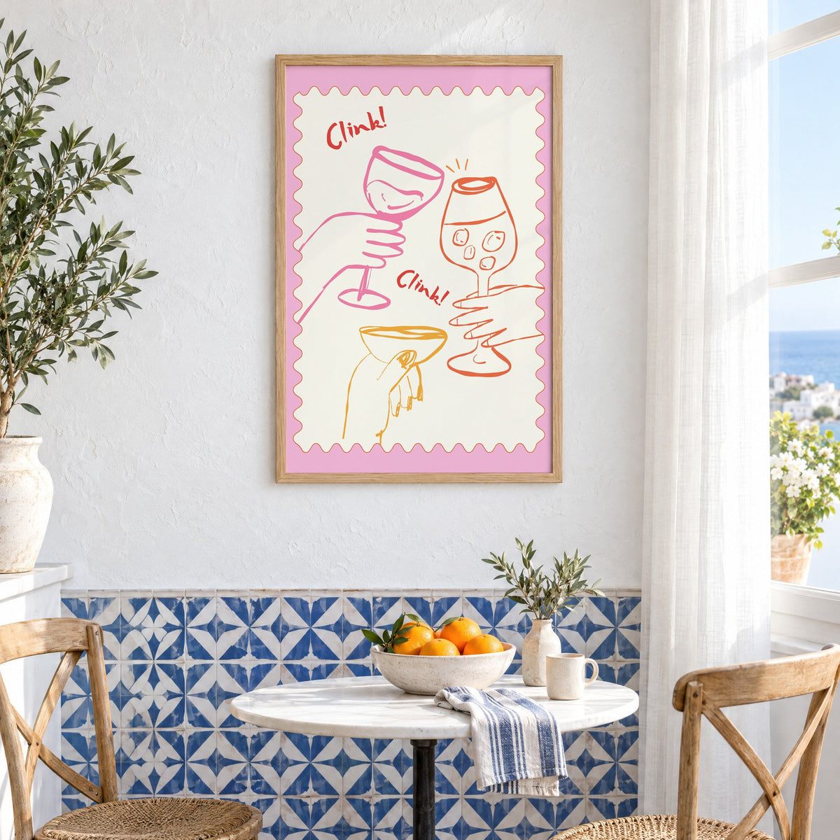 Clink Clink three glasses toast print in an oak frame above a bistro table and blue patterned tiles