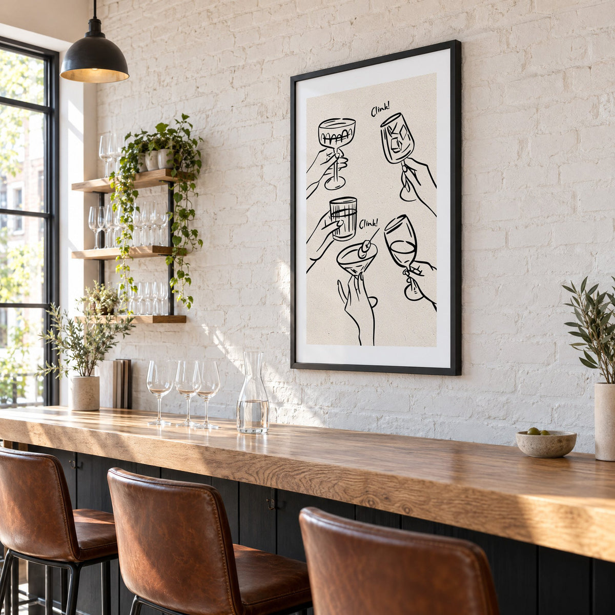 Clink! black line-art cocktail toast print in a black frame on a white brick wall above a wine bar counter