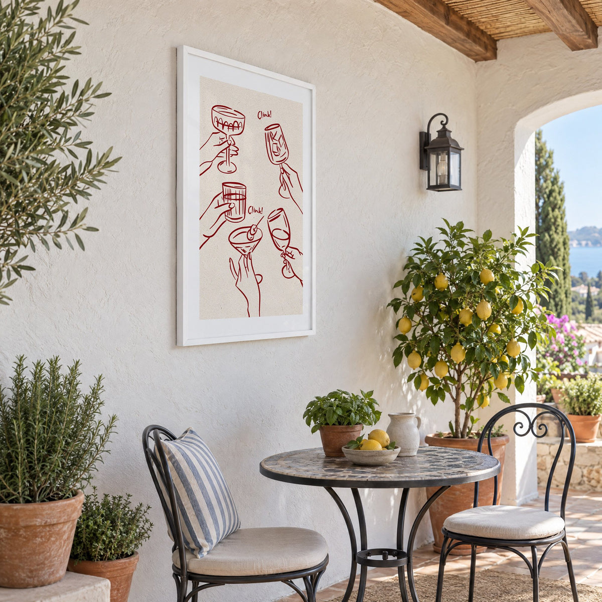 Clink! wine-red cocktail toast print in a white frame on a sunny patio wall beside a potted lemon tree