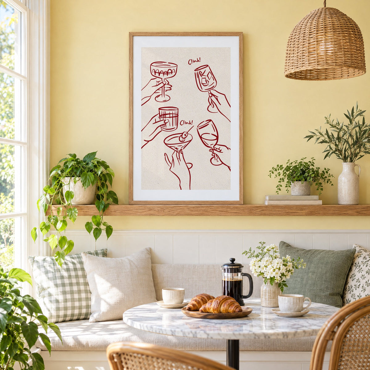 Clink! wine-red cocktail toast print in an oak frame on a picture ledge above a sunny breakfast nook