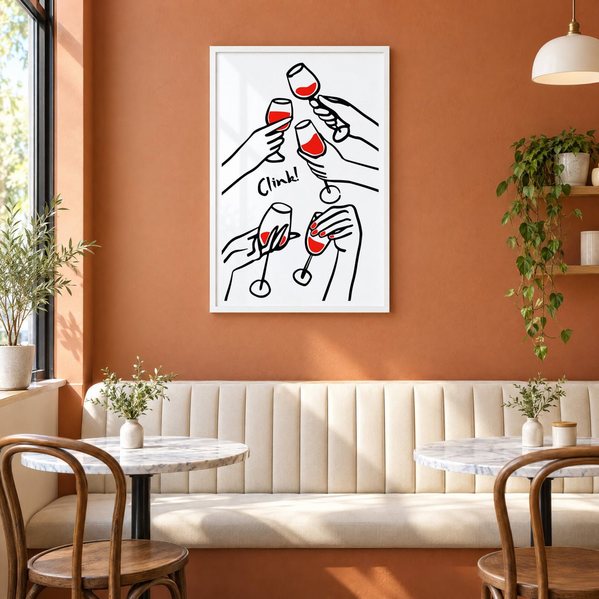 Clink five hands red wine toast print in a white frame above a cream banquette on a terracotta cafe wall