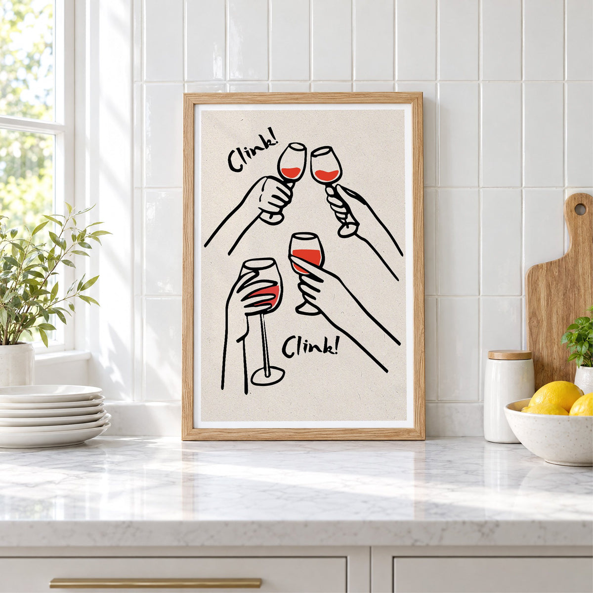 Clink! red wine toast kraft print in an oak frame leaning on a marble counter by white tiles and lemons