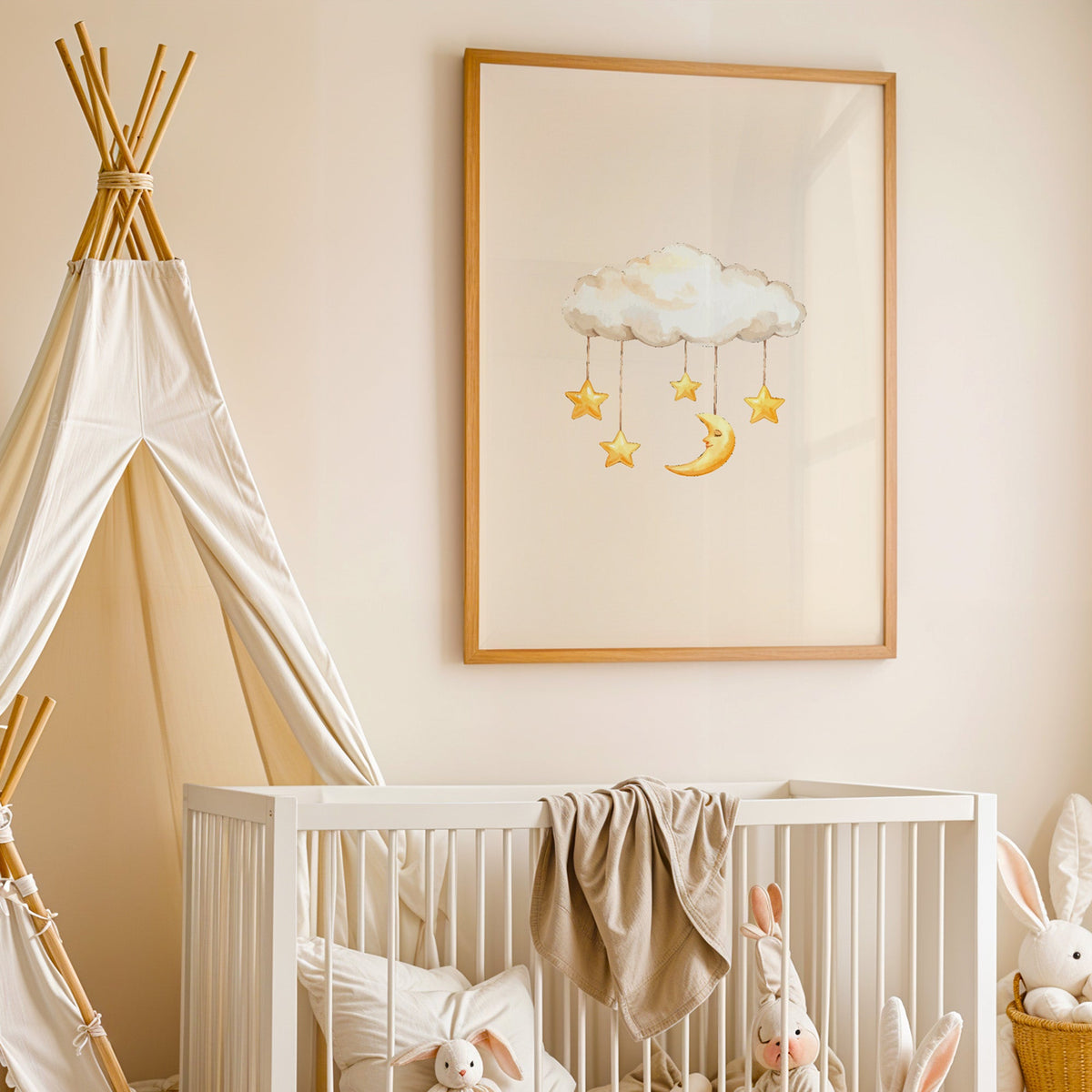 Cloud mobile with moon and stars nursery print in an oak frame above a white crib beside a canvas teepee