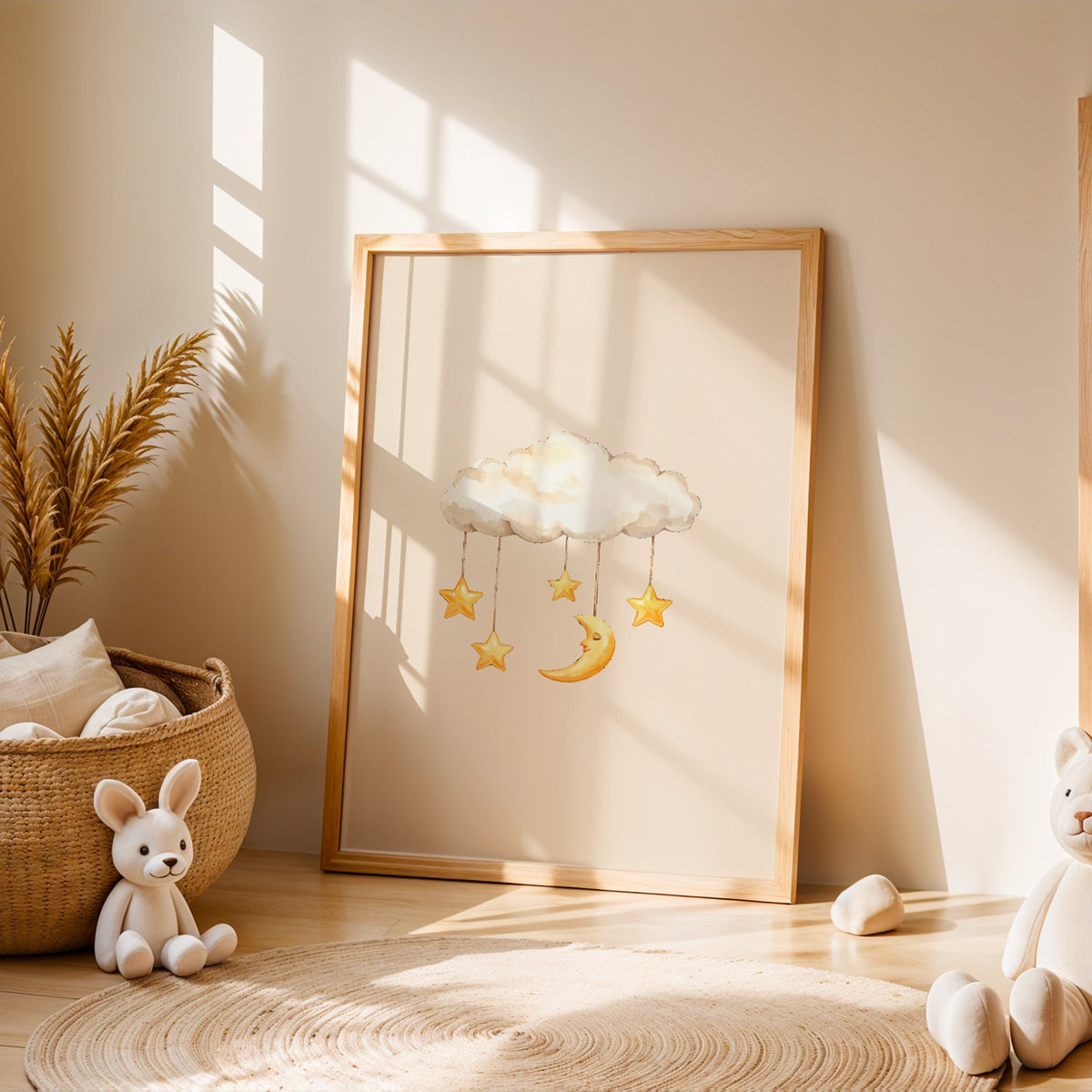 Cloud mobile with moon and stars nursery print in an oak frame leaning on a sunlit floor by a woven basket