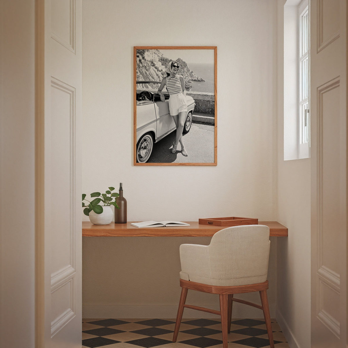 Woman leaning on vintage convertible by the sea print in an oak frame above a home office desk nook