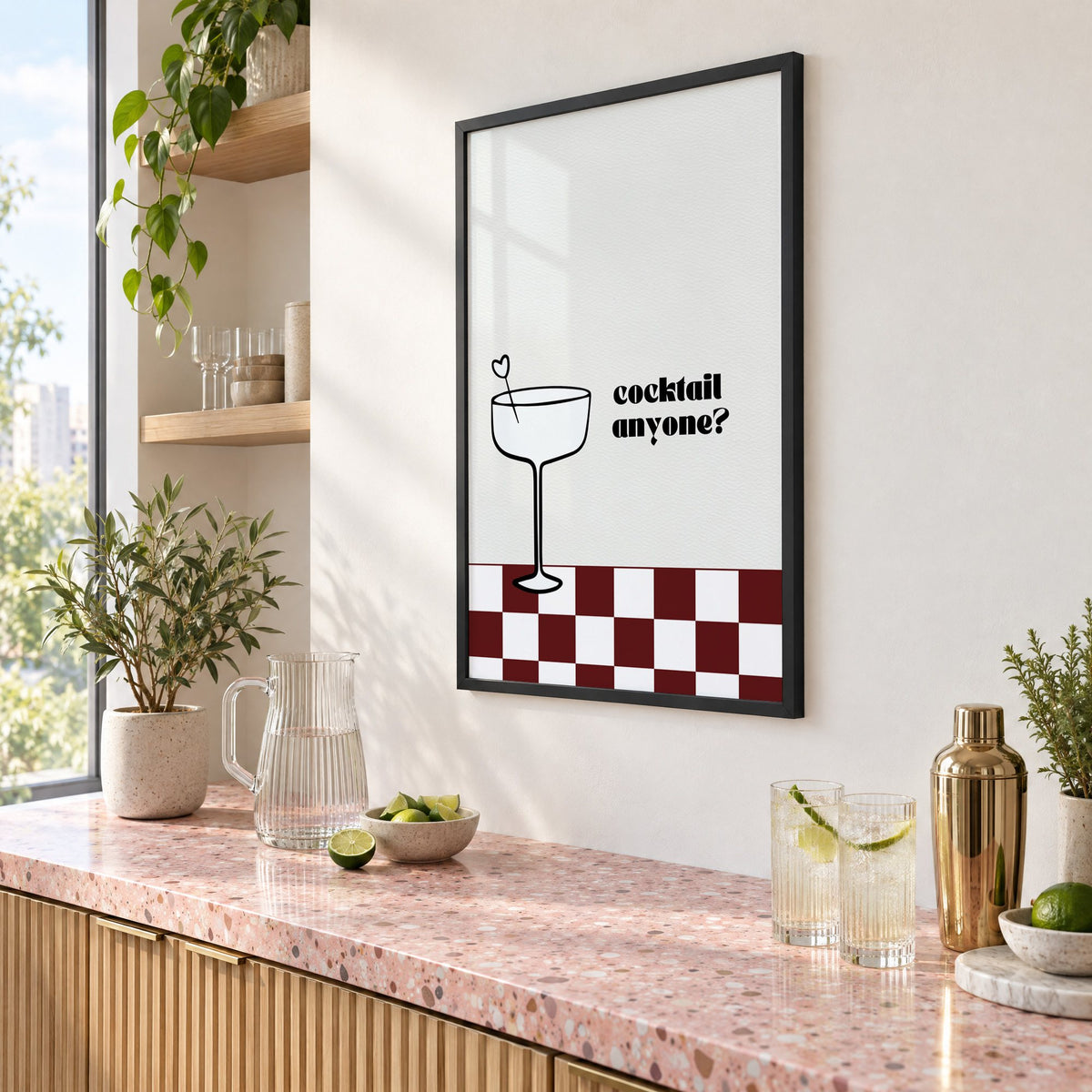 Cocktail anyone coupe check print in a black frame above a pink terrazzo cocktail counter with limes, seen at an angle