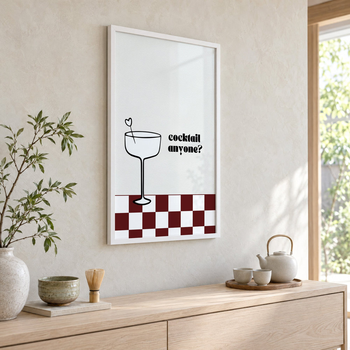 Cocktail anyone coupe check print in a white frame above a pale wood console with a matcha tea set