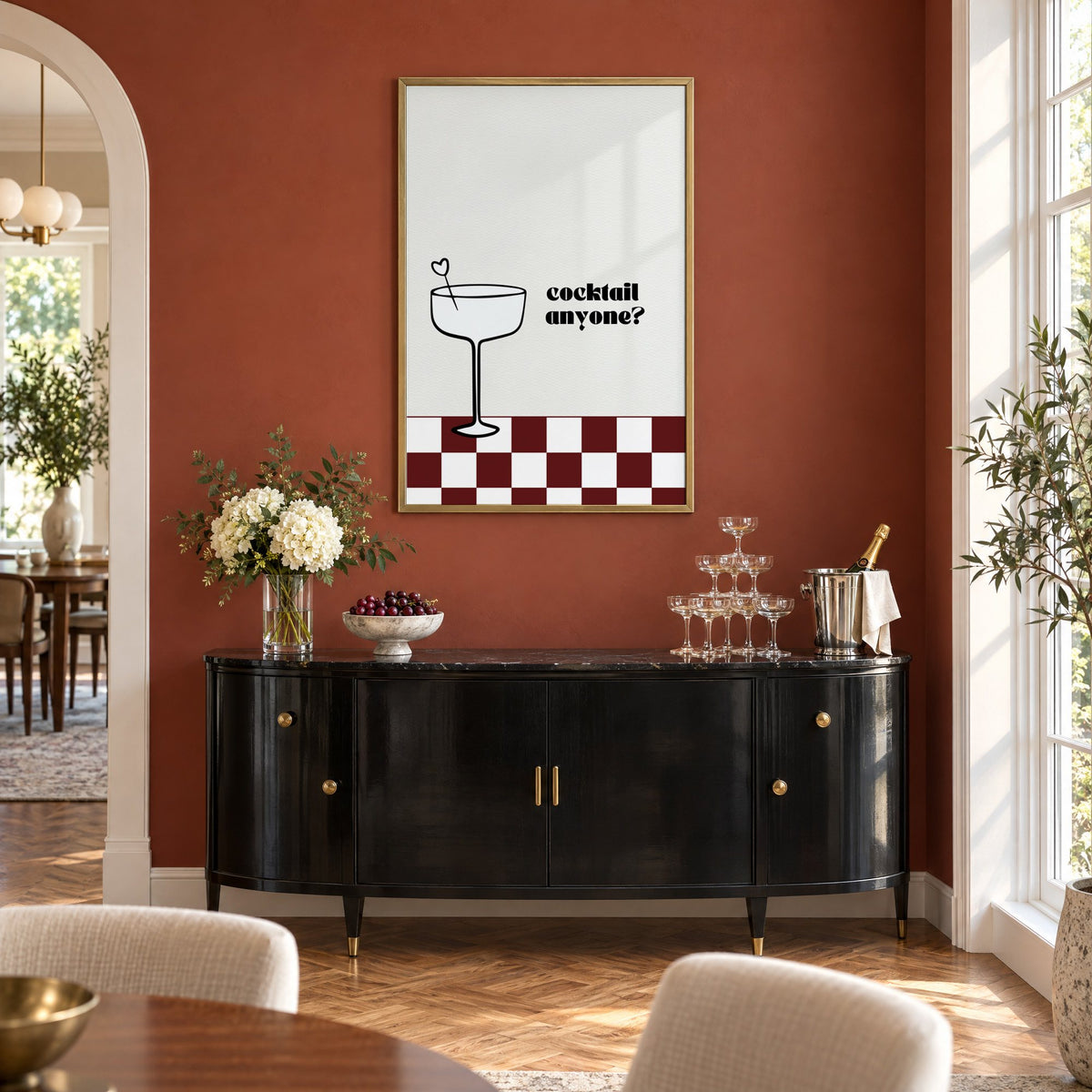Cocktail anyone coupe check print in a brass frame on a terracotta wall above a black buffet with a champagne tower