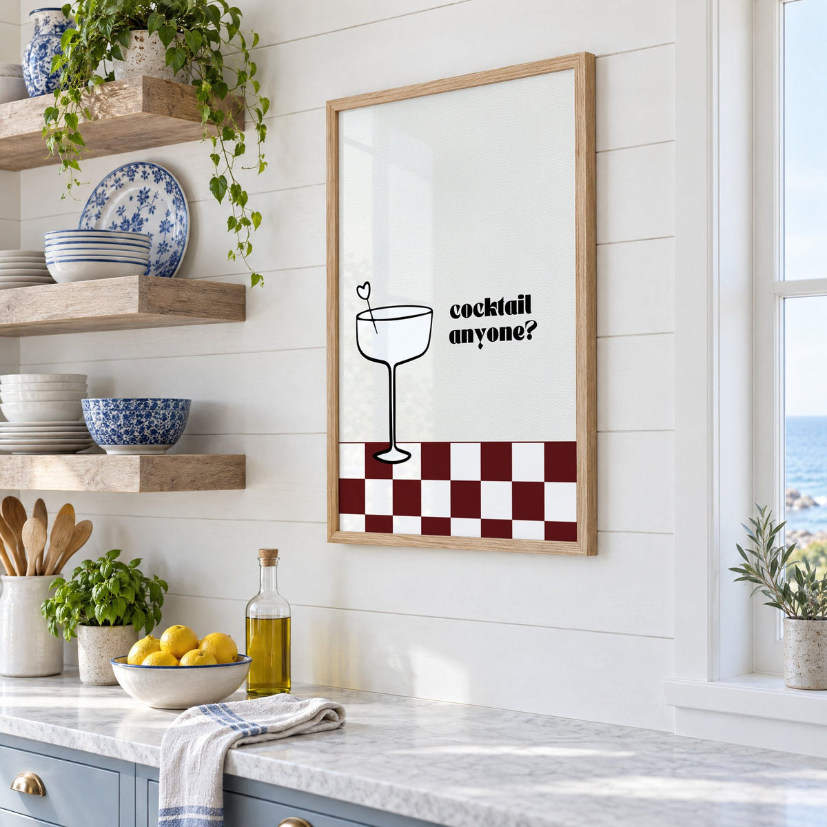 Cocktail anyone coupe check print in an oak frame in a white coastal kitchen beside blue and white plates