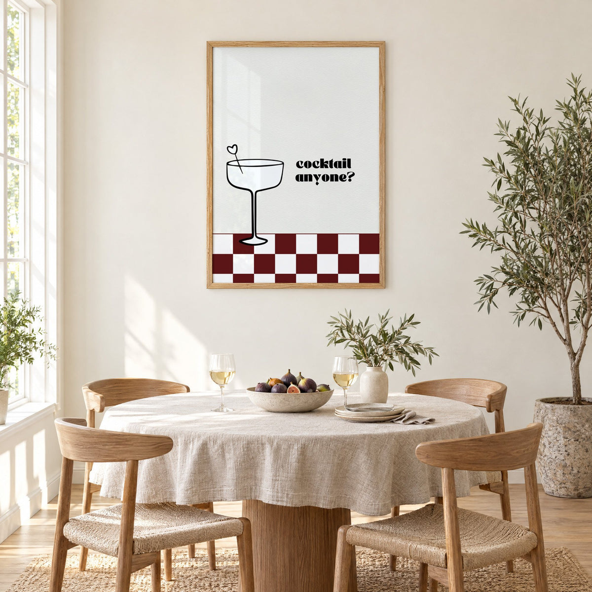 Cocktail anyone coupe check print in an oak frame above a round linen-covered dining table with figs and wine