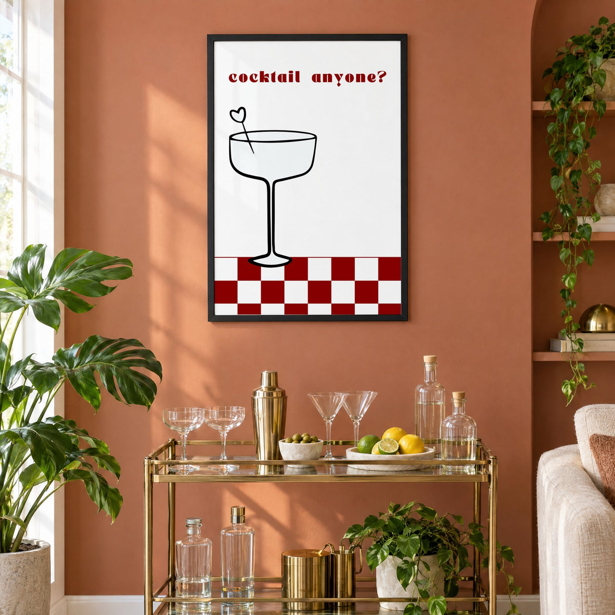 cocktail anyone? coupe check floor print in a black frame on a terracotta wall above a brass bar cart with coupes and citrus