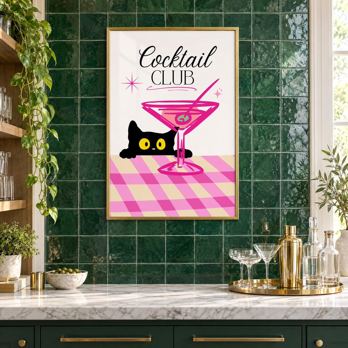 Cocktail Club black cat martini print in a brass frame on emerald green tiles above a home bar with coupe glasses