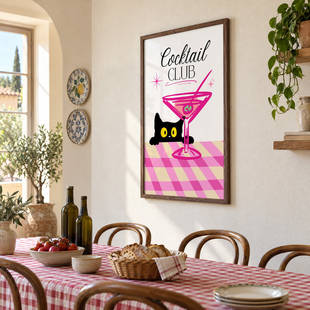 Cocktail Club black cat martini print in a walnut frame above a gingham-covered trattoria table, seen at an angle
