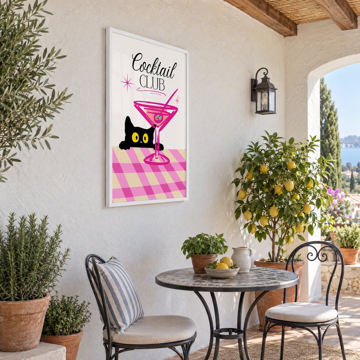 Cocktail Club black cat martini print in a white frame on a sunny patio wall beside a potted lemon tree