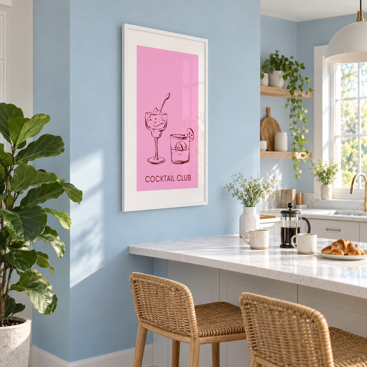 Cocktail Club sketched glasses pink print in a white frame on a pale blue wall above a breakfast bar with rattan stools