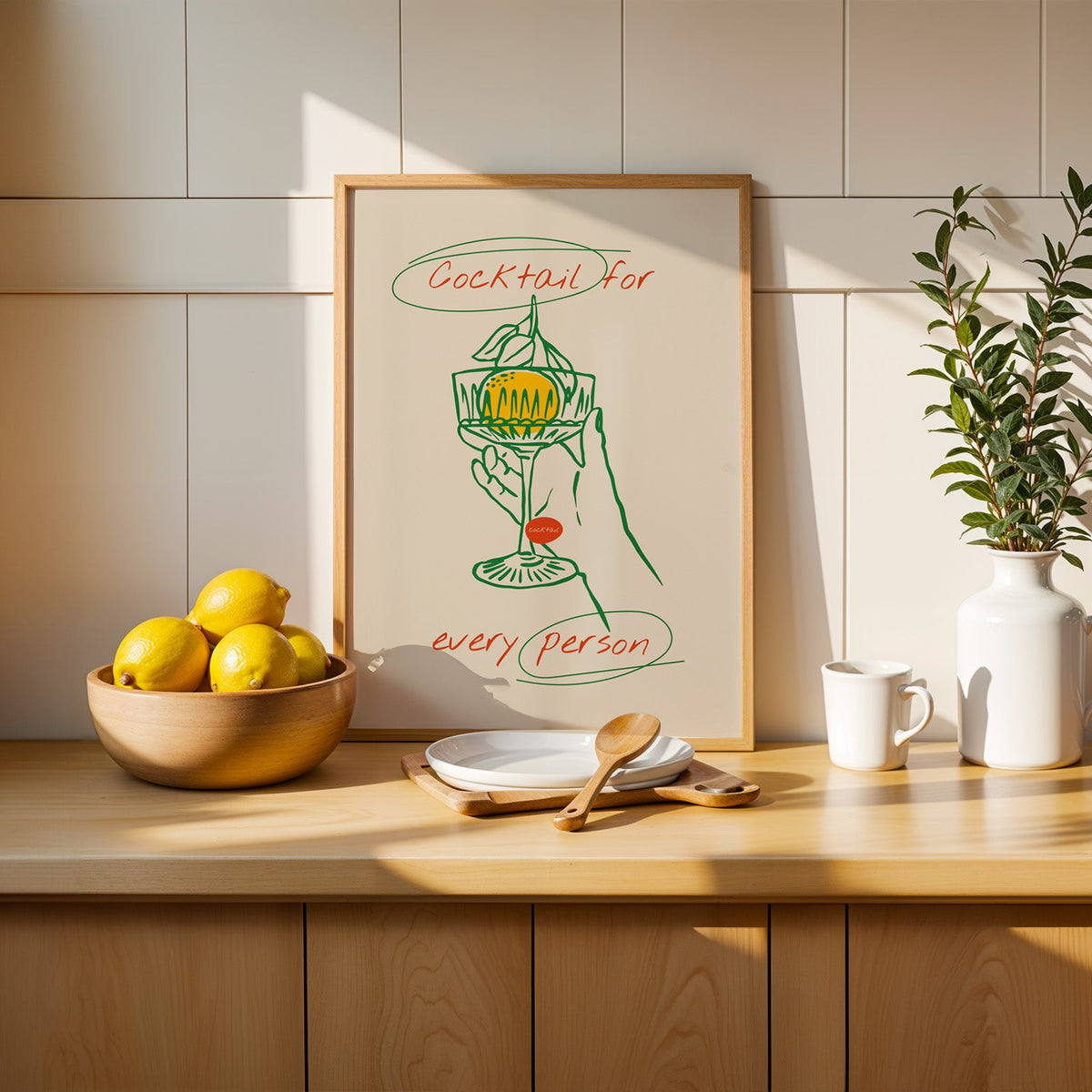 Cocktail for Every Person print in a slim oak frame beside a wooden bowl of lemons