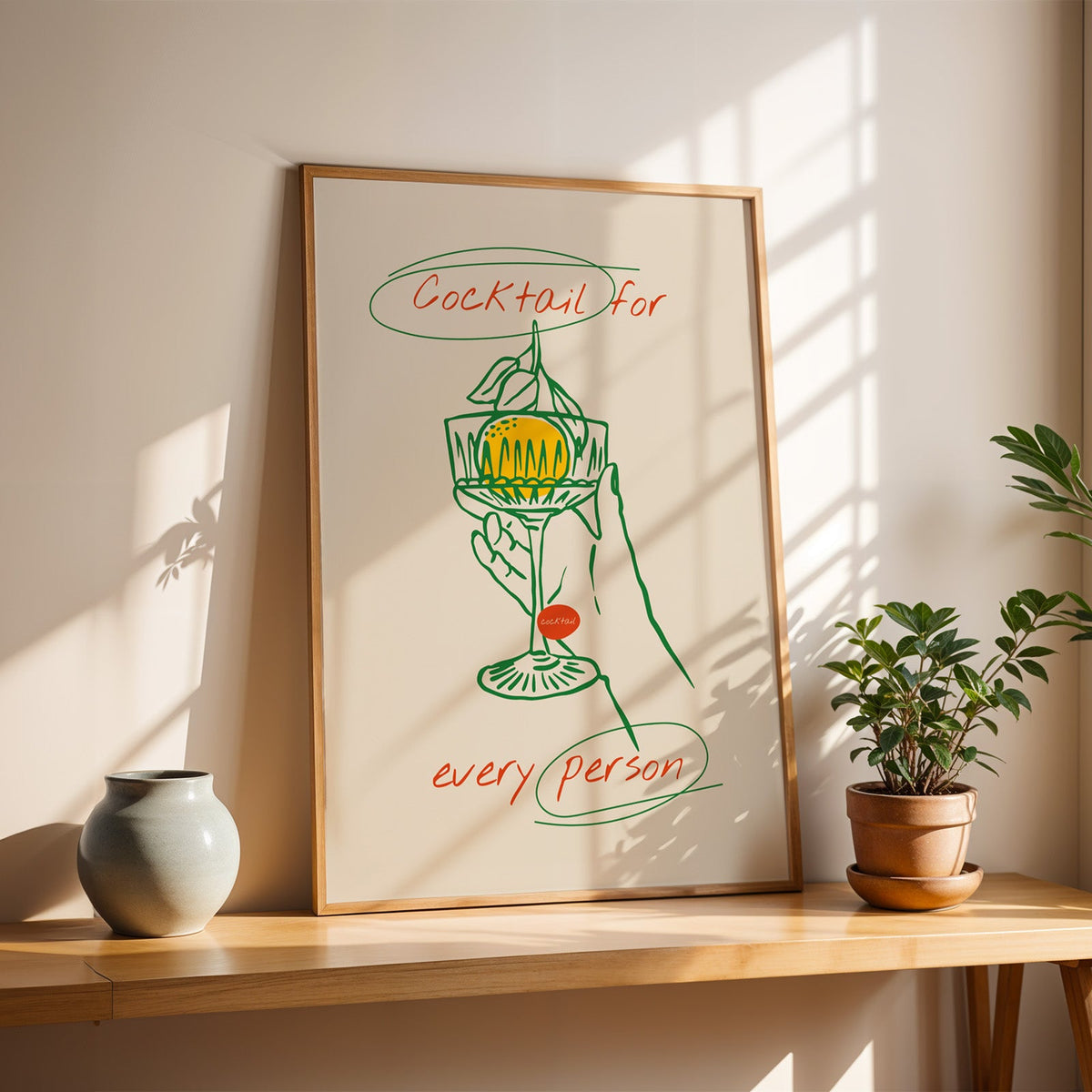 Cocktail for Every Person print in a slim oak frame on a console with a grey-blue vase