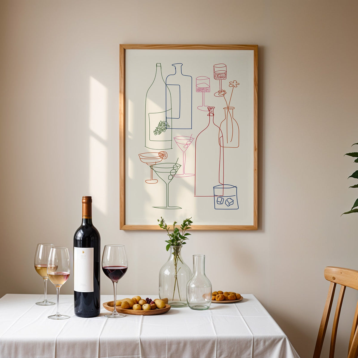 Cocktail glassware line art print in an oak frame above a table laid with red wine and glasses