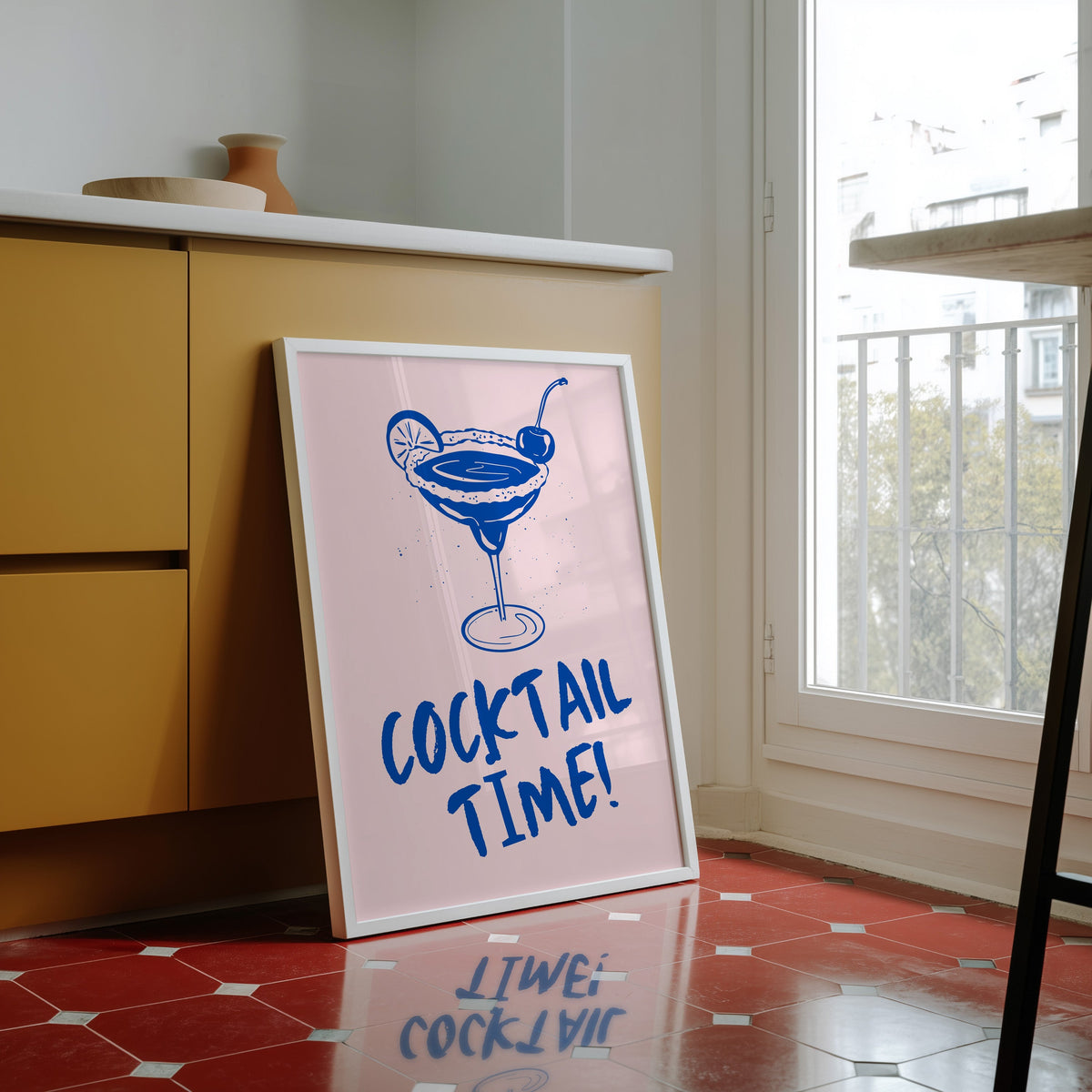 Cocktail Time margarita print in a white frame against yellow cabinets on a red tiled floor