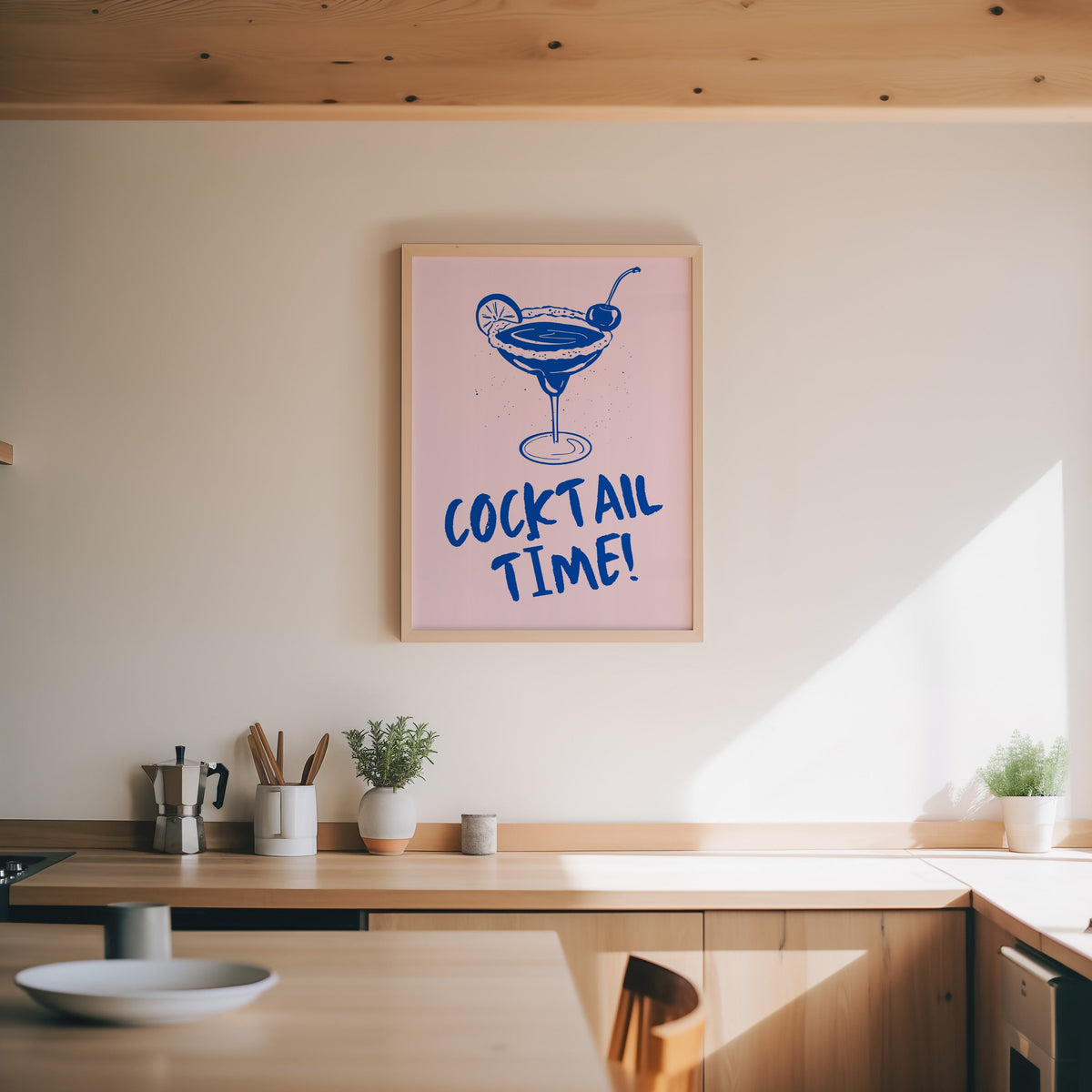 Cocktail Time margarita print in an oak frame above a wood counter with a moka pot and herbs