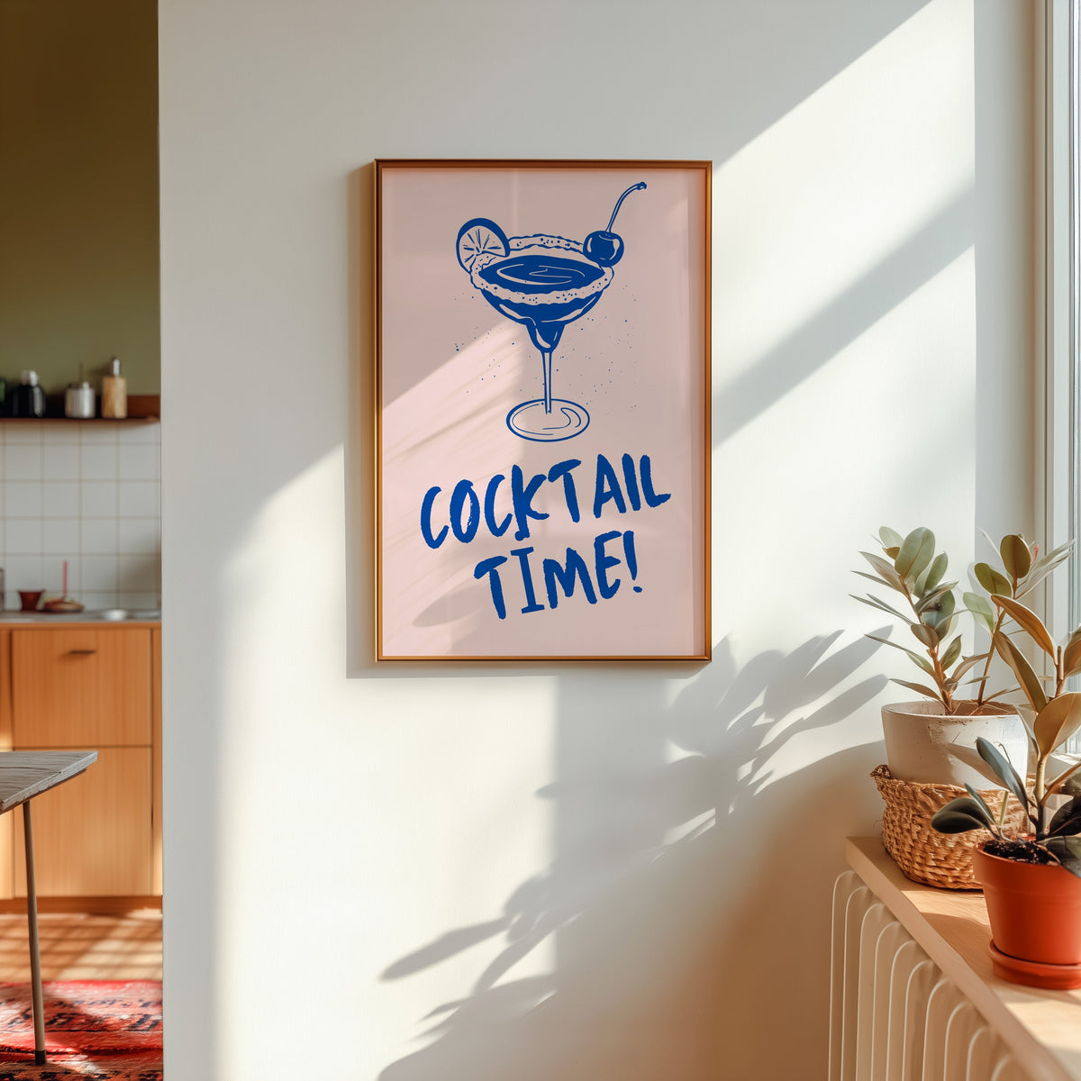 Cocktail Time margarita print shown in a gold frame in sunlight with plants and a kitchen beyond
