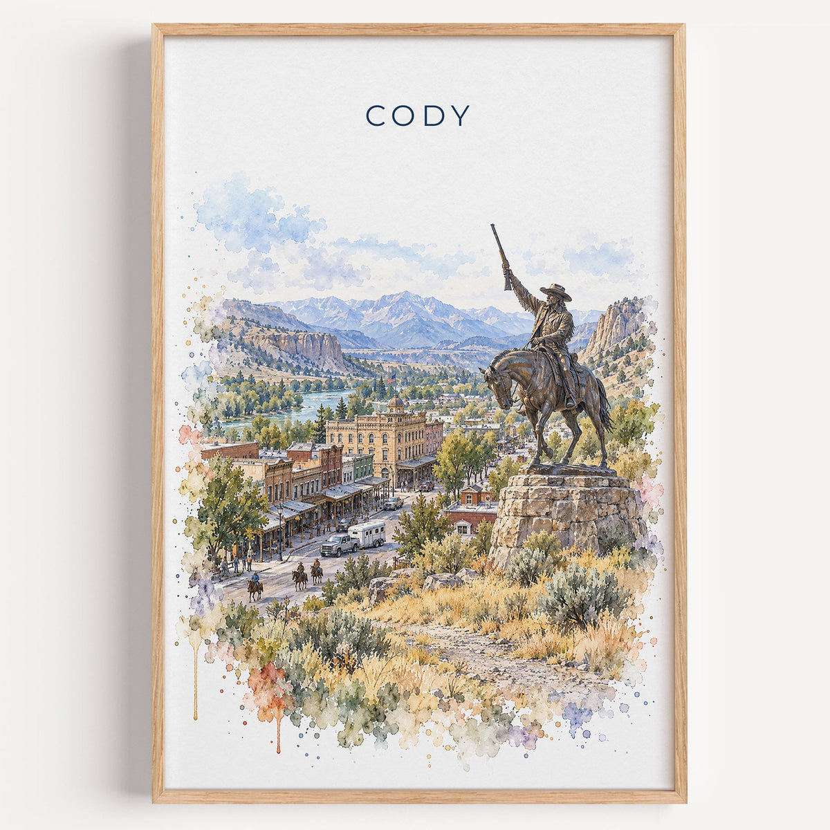 Cody, Wyoming watercolor print in a light oak frame on a plain white wall
