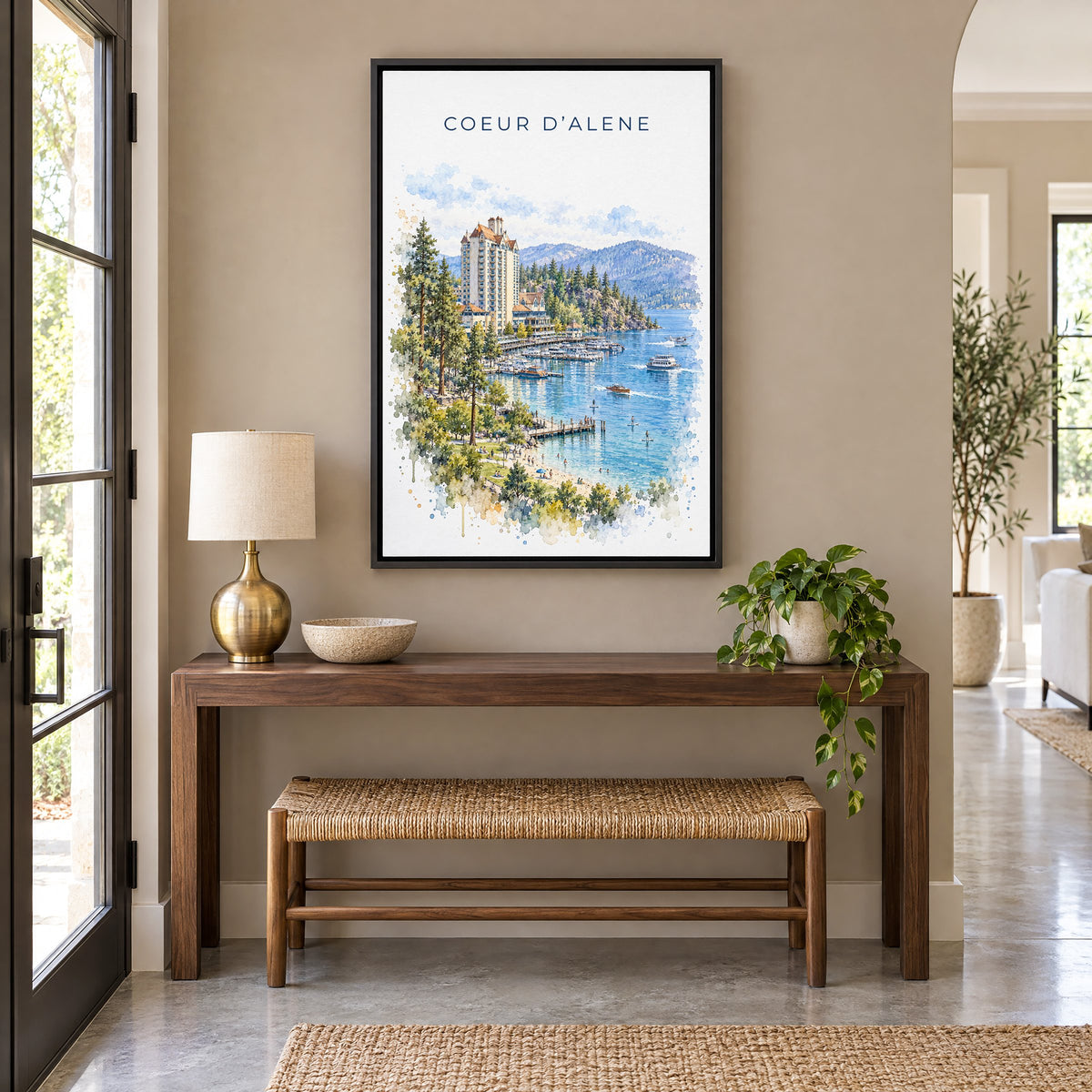Coeur d'Alene watercolor print as a black floater canvas above a walnut console and woven bench in an entryway