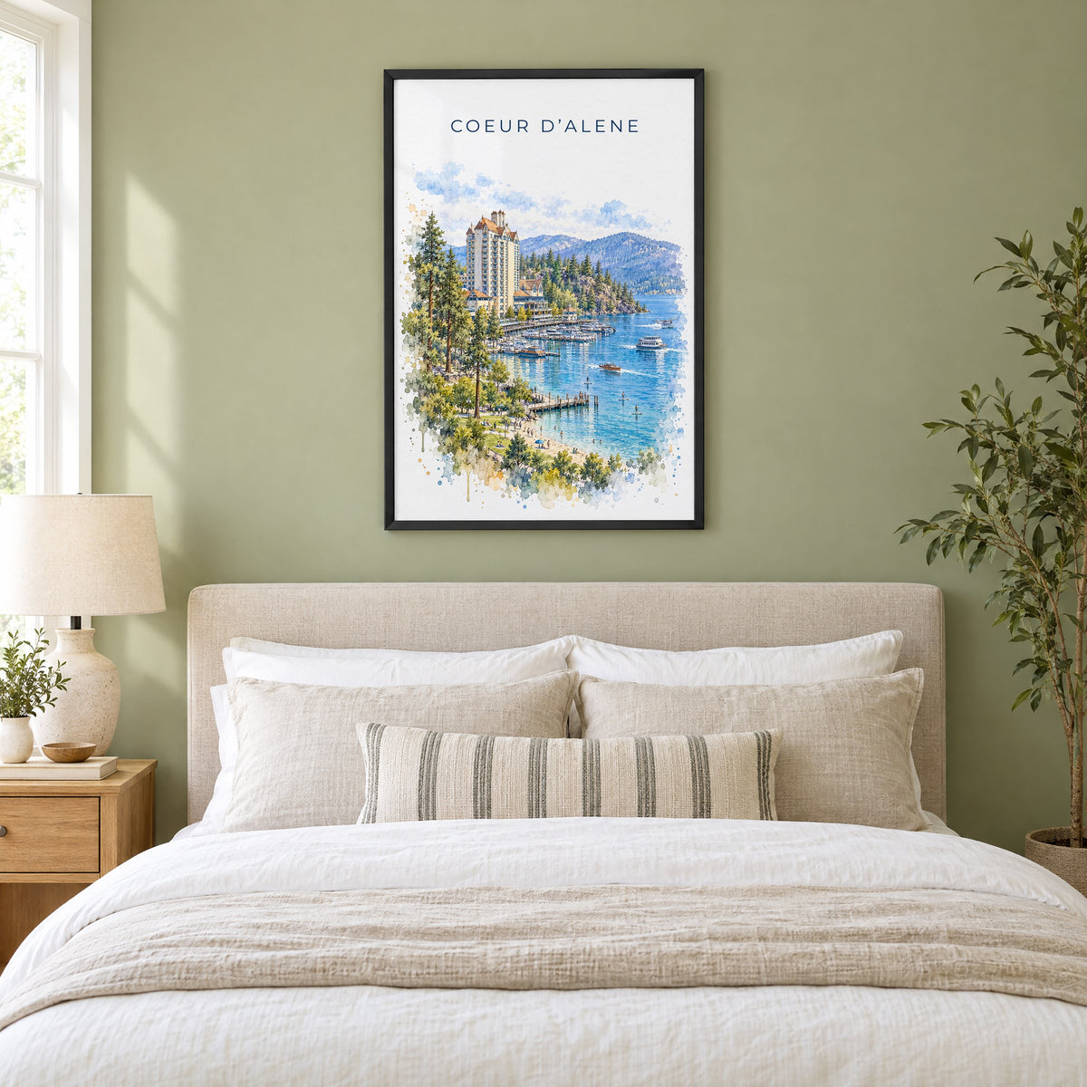 Coeur d'Alene watercolor print in a black frame above an upholstered headboard in a sage green bedroom