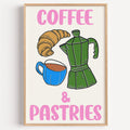 Coffee and pastries print in a light oak frame on a plain white wall
