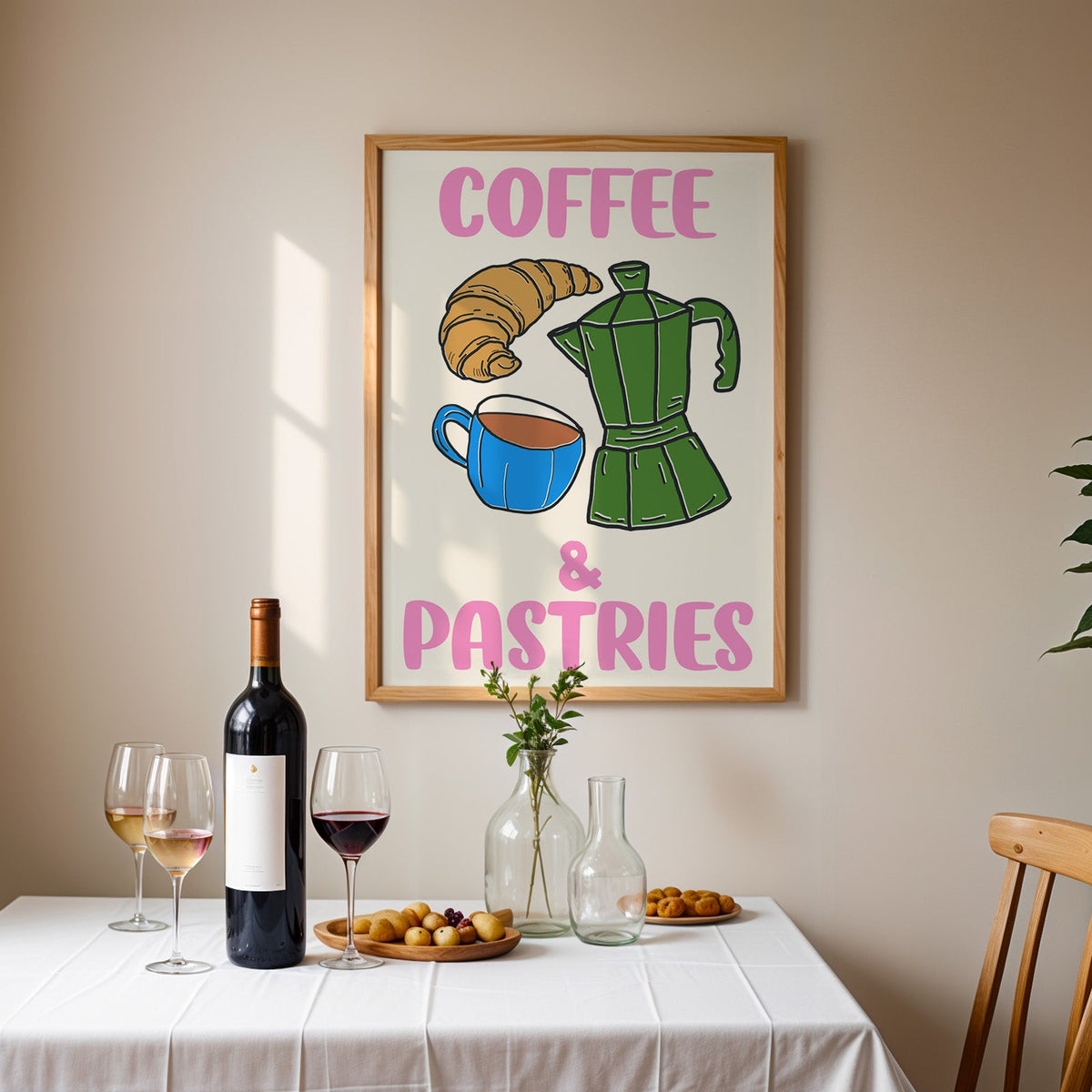 Coffee and pastries print in an oak frame above a table laid with red wine and glasses