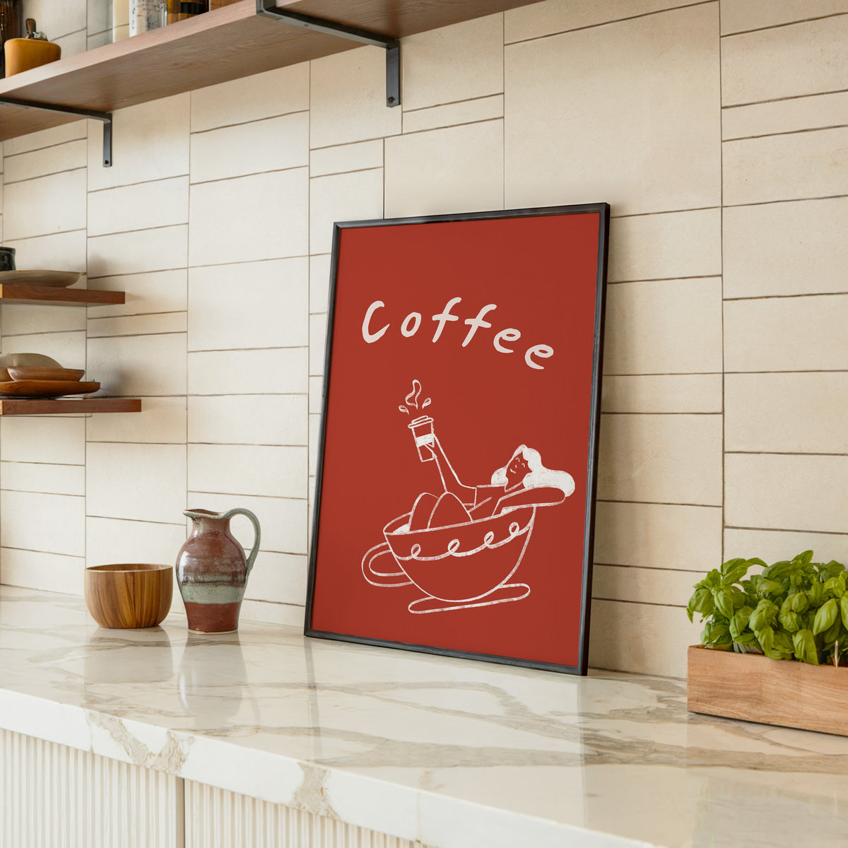 Coffee Bath print in a black frame leaning on a marble counter in a tiled kitchen