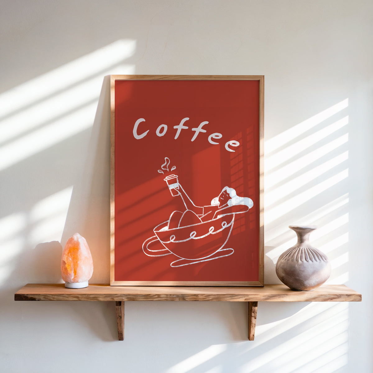 Coffee Bath print in an oak frame on a live-edge shelf beside a salt lamp