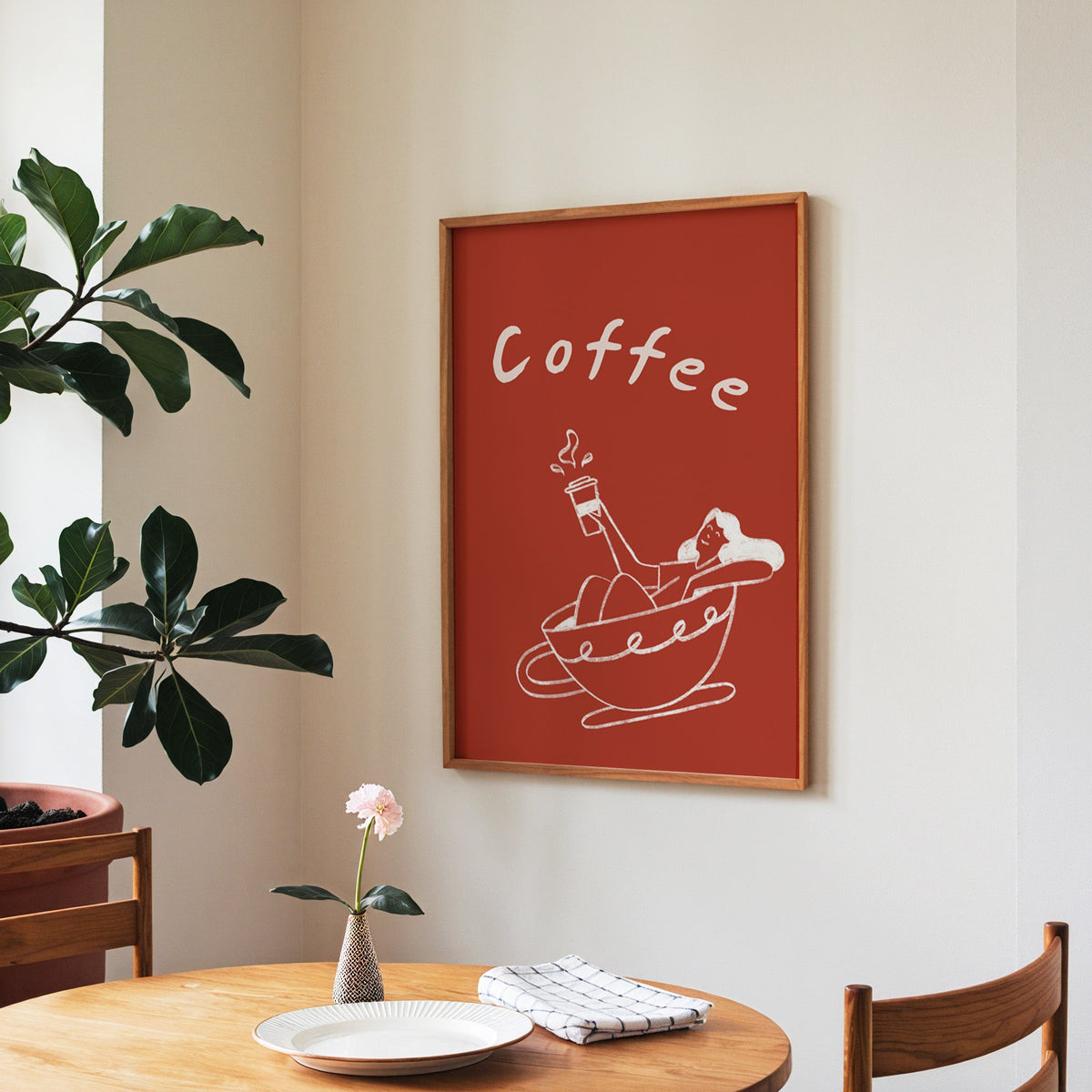 Coffee Bath print in a walnut frame above a round table beside a fiddle-leaf fig