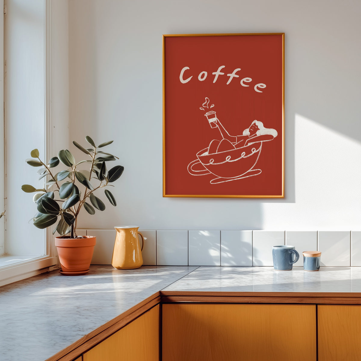 Coffee Bath print shown in a gold frame above a marble counter in a tan kitchen