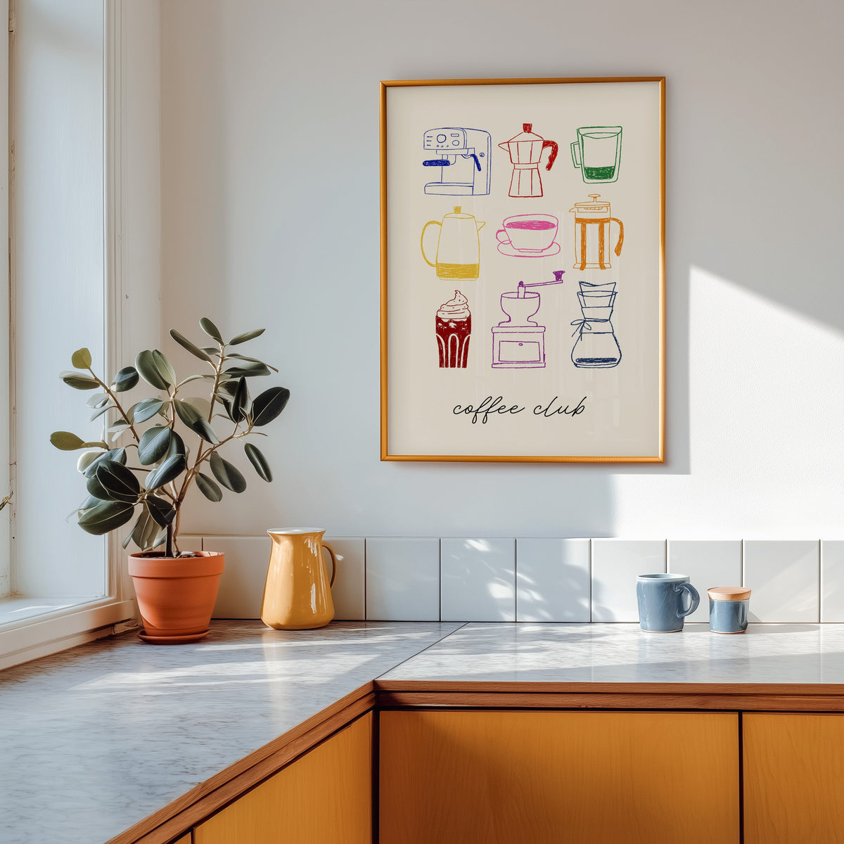 Coffee club print in a gold frame above a marble counter with a yellow ceramic jug