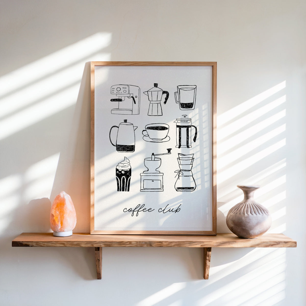 Coffee Club brewer grid print in an oak frame on a live-edge shelf beside a salt lamp