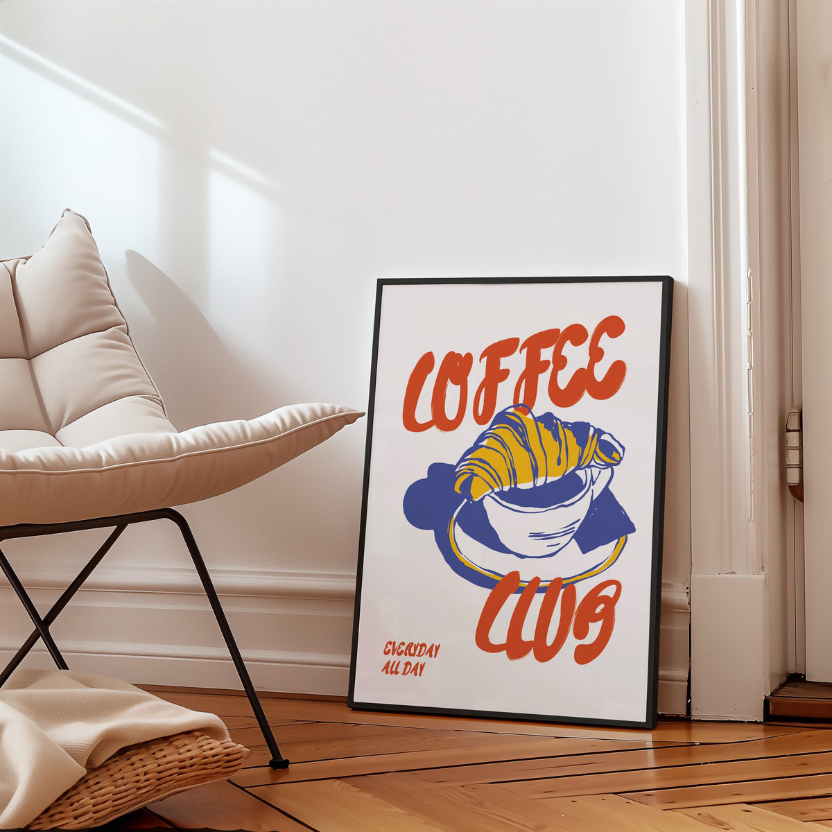 Coffee Club croissant print in a black frame on a parquet floor