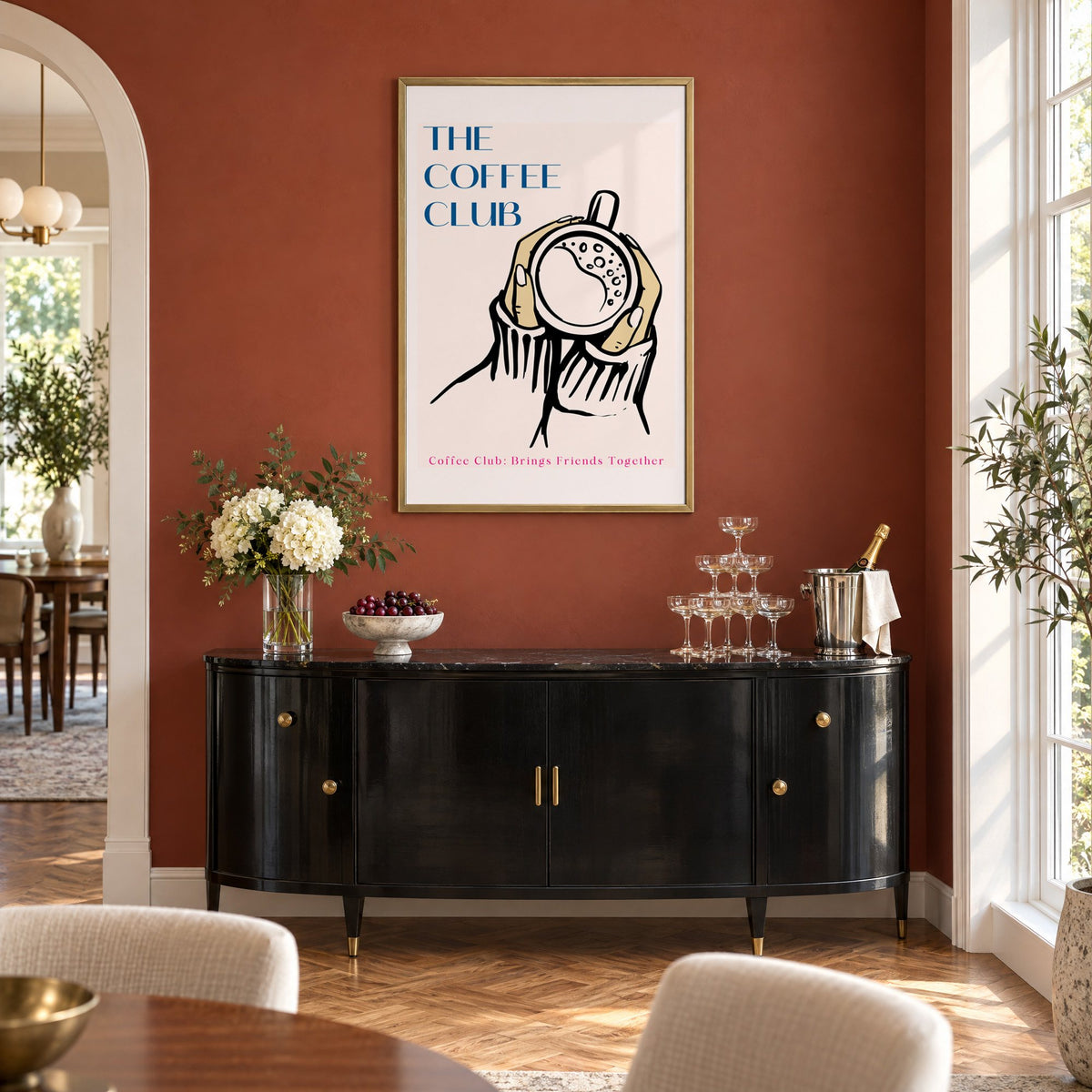 The Coffee Club hands and cup print in a brass frame on a terracotta wall above a black buffet with a champagne tower