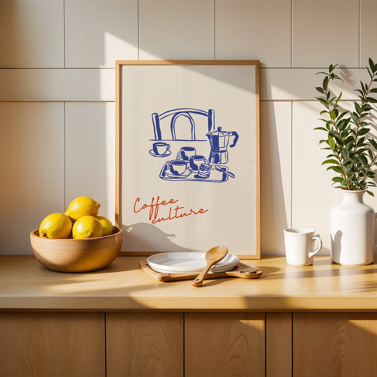 Coffee Culture poster in an oak frame on a kitchen counter beside a wooden bowl of lemons